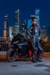 Портрет мотоциклистки на фоне ночного города