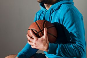 side-view-man-hoodie-sunglasses-holding-basketball-close-chest