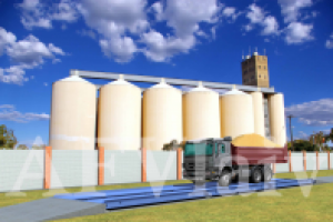 Изображение автомобильных весов с грузовиком на фоне элеватора