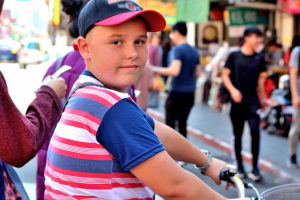 Мальчик на велосипеде на городской улице